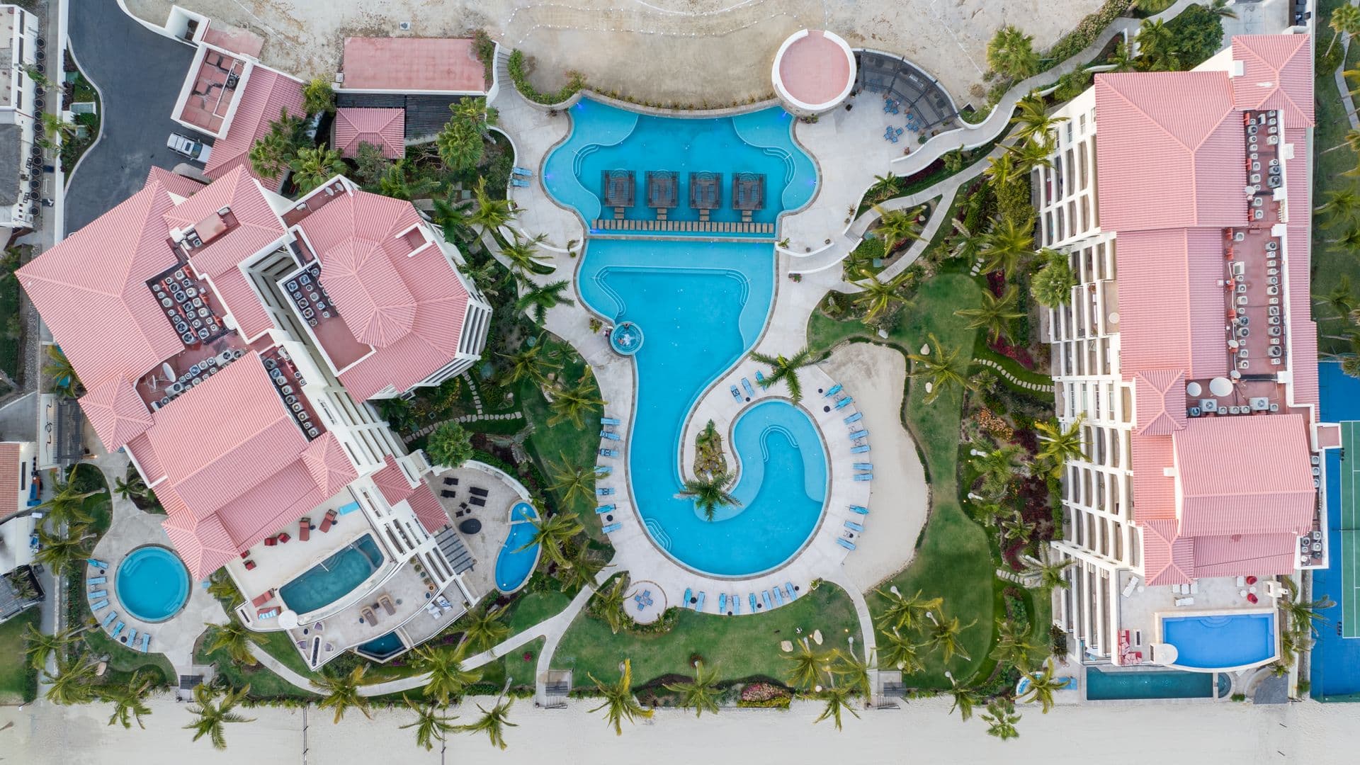 An aerial view of the resort's pools and gardens above the coastline
